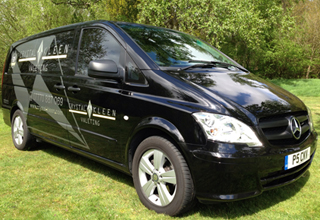 image of Crystal Kleen black van parked on the grass in the sun