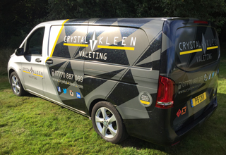  image of Crystal Kleen black, white and grey van parked on the grass in the sun